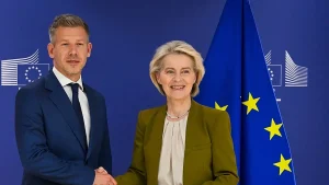 Петер Мадяр і Урсула фон дер Ляєн тиснуть руки на тлі прапорів ЄС