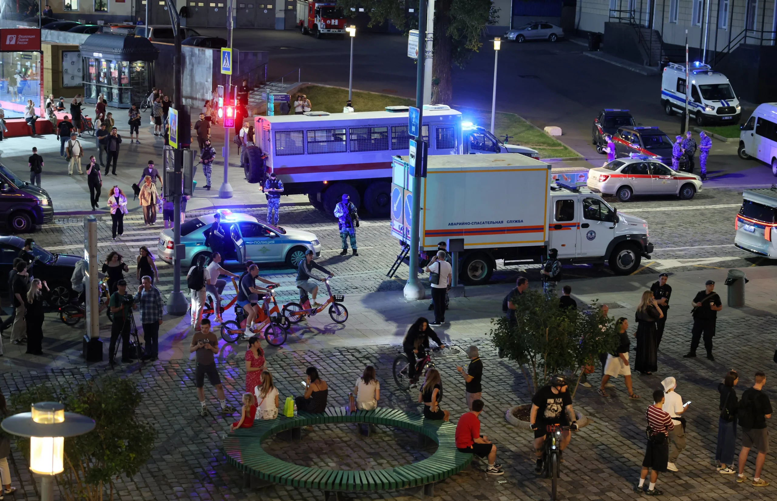 Нічна площа в Москві з поліцією аварійними службами натовпом людей і велосипедистами